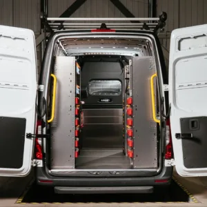 The back of an organized work van, with shelving units and drawer systems