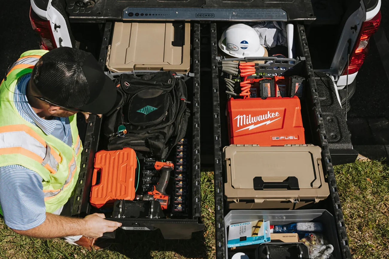 An overhead shot of someone getting gear from the back of their work truck using Decked storage drawers
