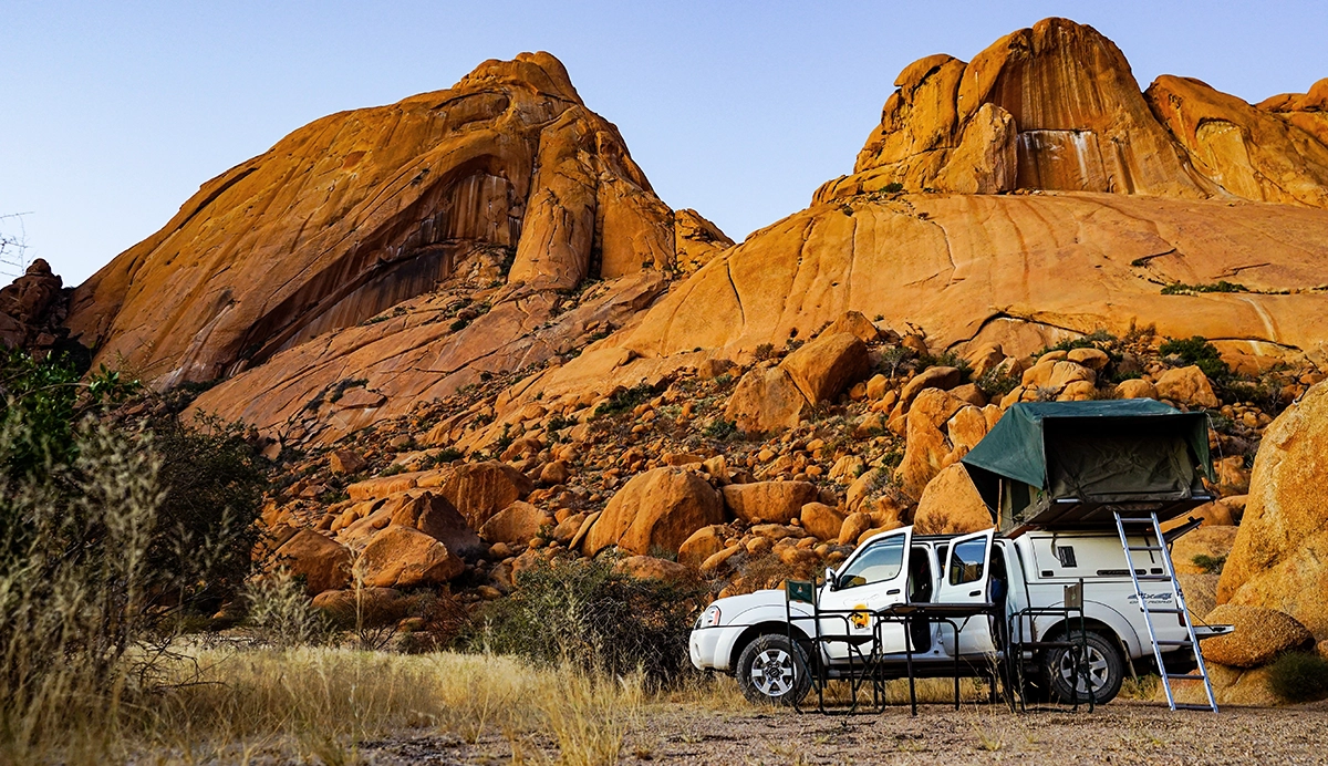 A white pickup truck with a rooftop tent, showing the concept of an overland trip