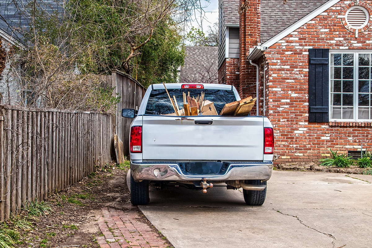 An overloaded pickup truck filled with lumber in a driveway