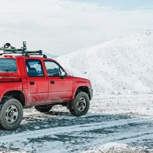 A red truck off-roading in the snow