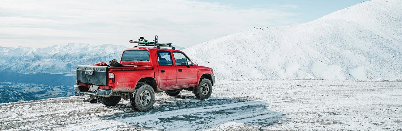 A red truck off-roading in the snow