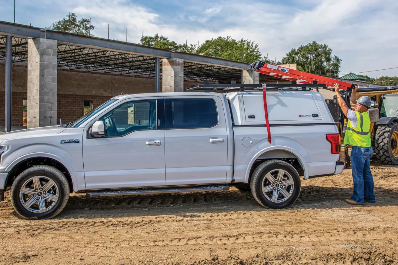 A silver pickup work truck with a RSI SmartCap EVO-c Commercial truck cap