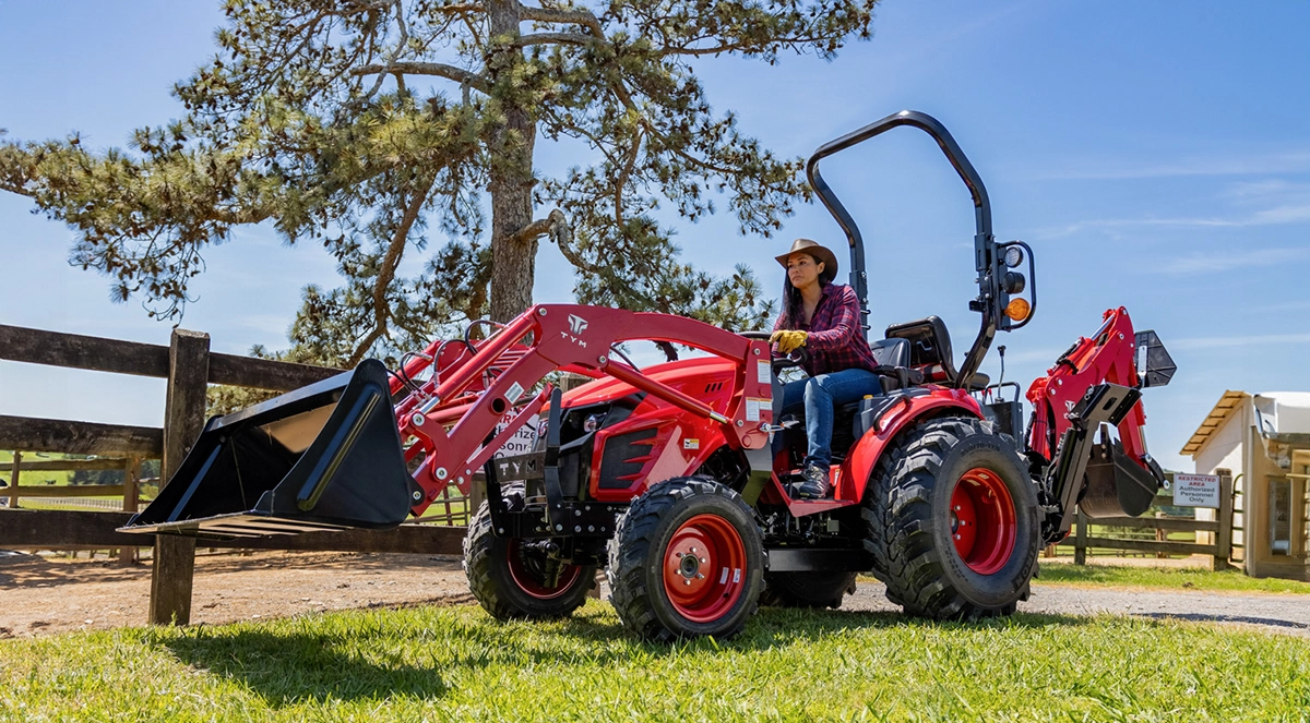 A red TYM Series 1 sub-compact tractor on a farm