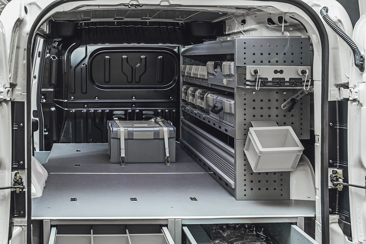 The interior of an upfitted commercial fleet work van, with drawers and organization systems, toolboxes, and other upgrades and accessories